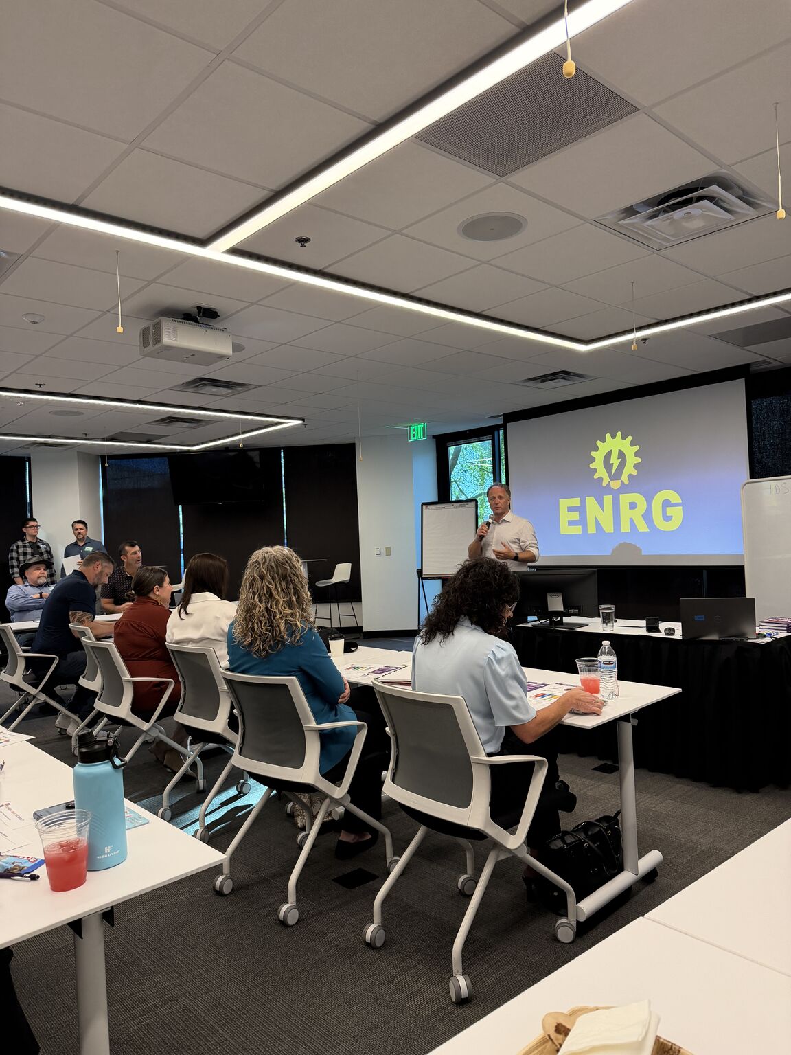 Rick Benton speaking with a microphone to entrepreneurs at ENRG Scottsdale